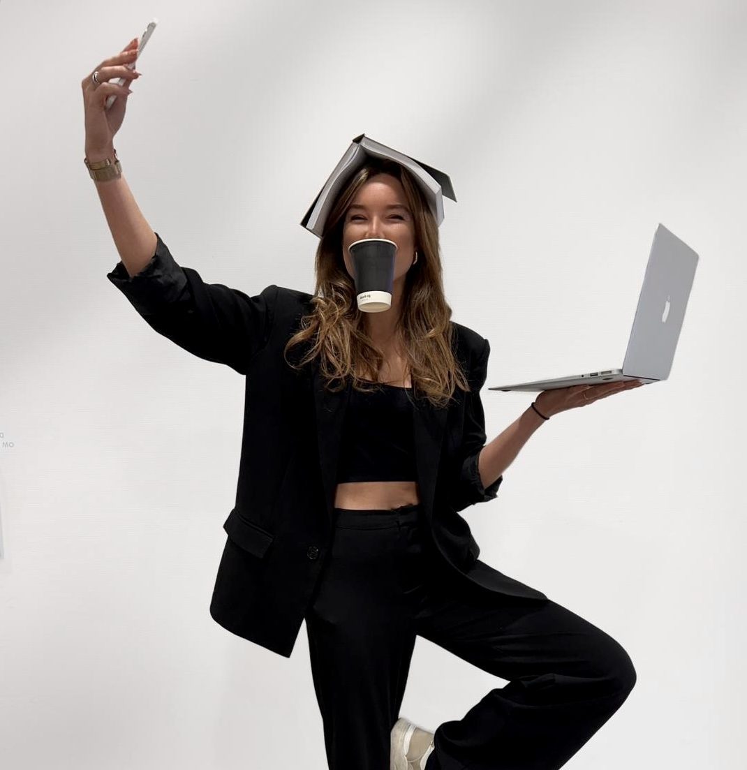 Romy van LIV Connect, speels portret met boek, koffie en laptop